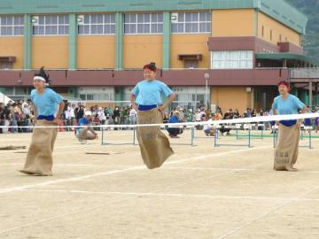 写真：麻袋に入ったまま競争する生徒ら