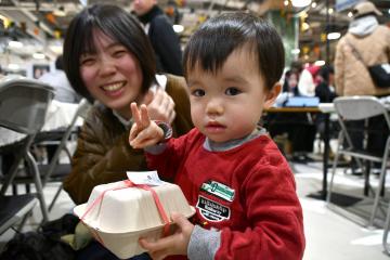 写真：米粉のおかし詰め合わせを手に微笑む親子