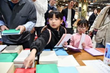 写真：手作りノートの紙を選ぶ姉妹