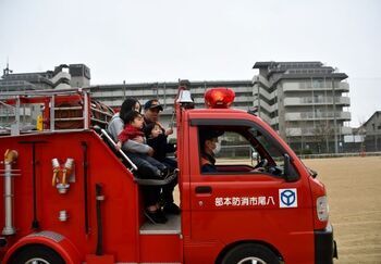 ミニ消防車両に乗る家族