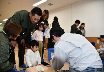 応急手当訓練に臨む子どもと家族