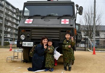 自衛隊車両と記念撮影をする家族