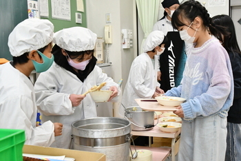 給食を配膳するこども
