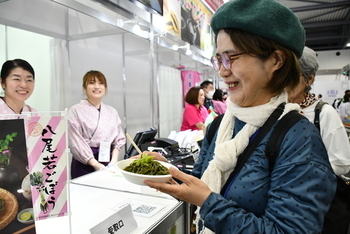 葉ごんぼそばを受け取られ、笑顔の女性