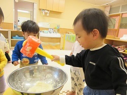 小麦粉粘土でもちつきごっこをする写真