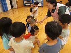 年齢の違う子どもたちが一緒に体操をしています