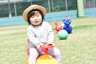 おもちゃの車に乗って笑顔の女の子