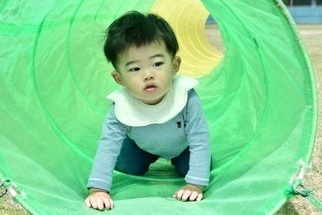 ビニールトンネルで遊ぶ男の子
