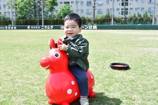 風船の馬に乗って笑顔の男の子