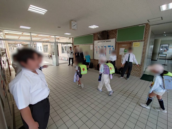 笑顔で小学生にあいさつする様子