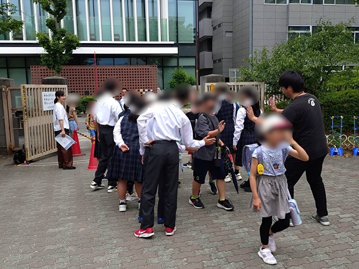 校門でハイタッチを交わす様子