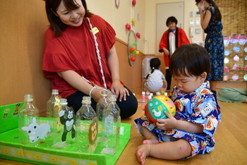 ボウリングのボールを眺める幼児と保護者