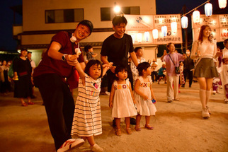 子どもの手を取り踊る男性たち