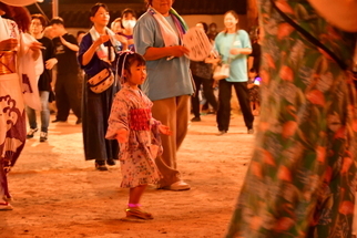 大人たちに見守られながら一人で踊る女の子