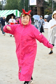 雨の中合羽を着て踊る女性