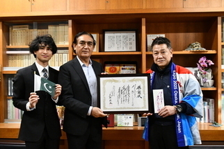 シャーさん、アルマンさん、市長が感謝状を手に記念撮影する様子