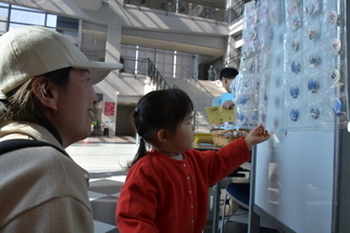ひゅーまんフェスタオリジナル缶バッジを選ぶ少女