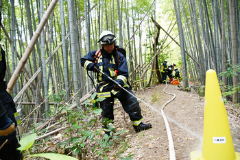 火点のホースに放水する消防士