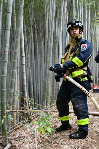 ホースを構え、隊長の指示を待つ消防士