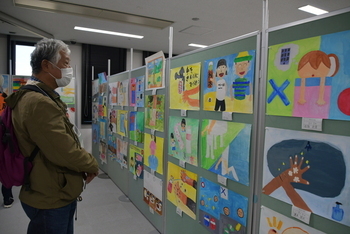 健康に関する児童絵画展を見る男性