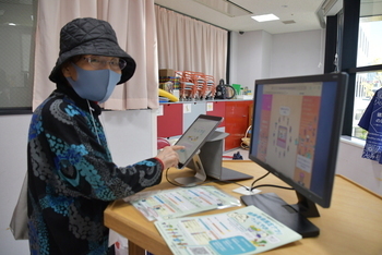 健康寿命推定アプリ「ウェルやお」を体験する女性