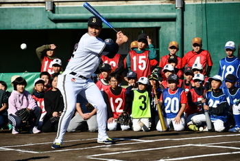 プロのバッティング練習を見つめる子供たち