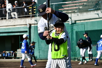 バッティングの構えについて指導してもらうこども