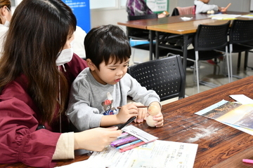 雪だるまに顔などを書く母親と男の子