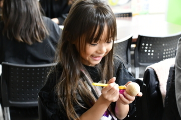 雪だるまに顔などを書く女の子