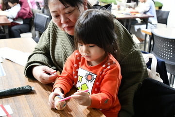 雪だるまに模様などを書く親子