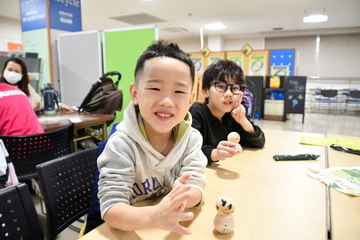 完成した雪だるまを持つ2人の男の子