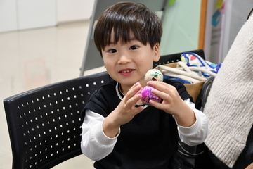 完成した雪だるまを両手で持つ男の子