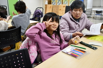 完成した雪だるまを持ちポーズを取る女の子
