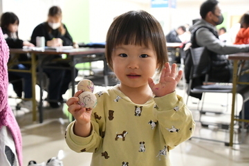 完成した雪だるまを持ちポーズを取る子ども