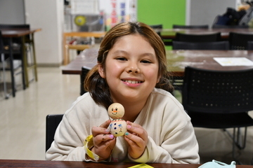 完成した雪だるまを両手で持つ女の子