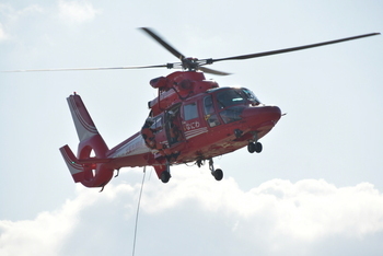 ヘリコプターから降りてくる消防士