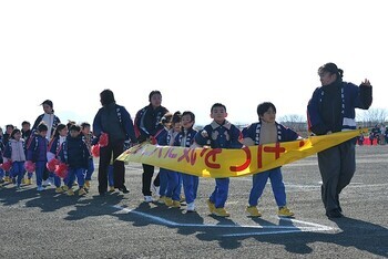 横断幕を掲げながら更新する園児たち