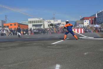 小型ポンプ機から伸ばしたホースで放水する消防団員