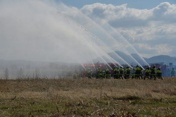 水を横並びで放水する消防団員ら