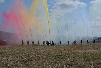 色のついた水を放水する消防職員たち
