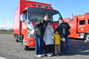 消防車の前で記念撮影する家族