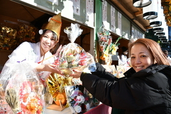 縁起物を福娘から受け取る女性