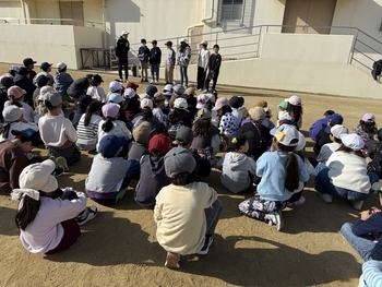 六年生の説明を聞く児童