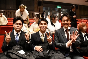 式典会場でポーズをとる男性3人