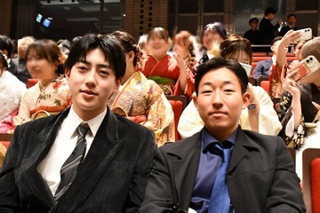 式典会場で座る男性2人