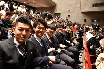 式典会場で並んで座る男性6人