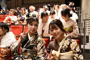 式典会場でピースをする女性2人