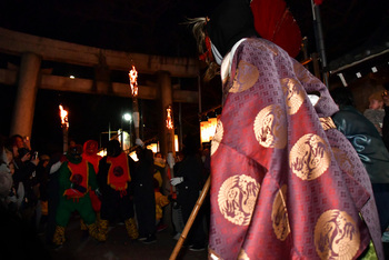 鳥居の前で3人の鬼と相対する神