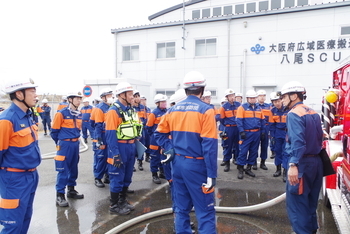 消火するための水を消防車から出すためにホースを伸ばして貯水槽から水を吸い上げます