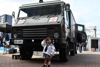自衛隊車両と記念撮影する少女